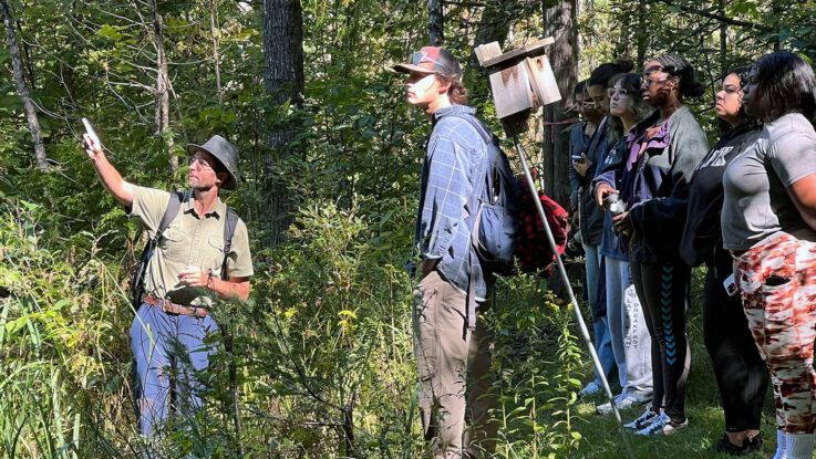a class learning outdoors in the woods