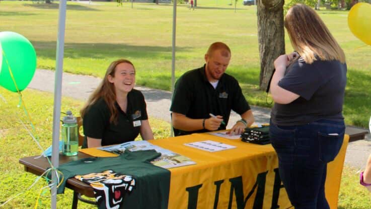 admissions staff greet a student at registration for student orientation