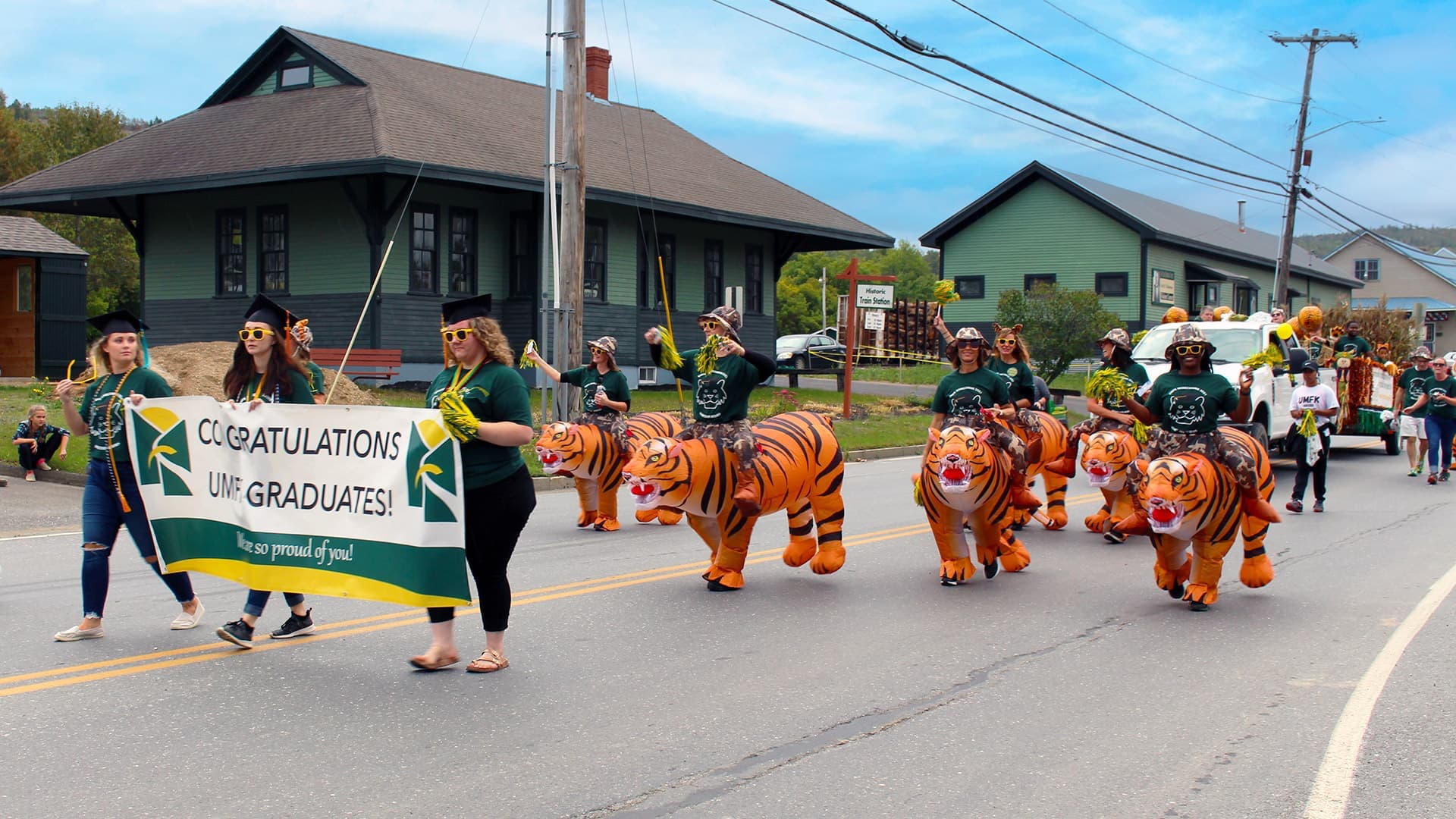UMFK students, staff, and alumni march in a homecoming parade, some wearing inflatable bengals