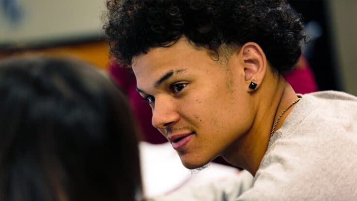 a new student sites in class talking to one of his classmates