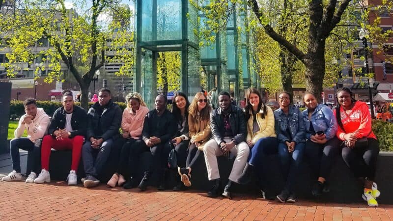 Students sit in front of the New England Holocaust Memorial in Boston, Massachusetts