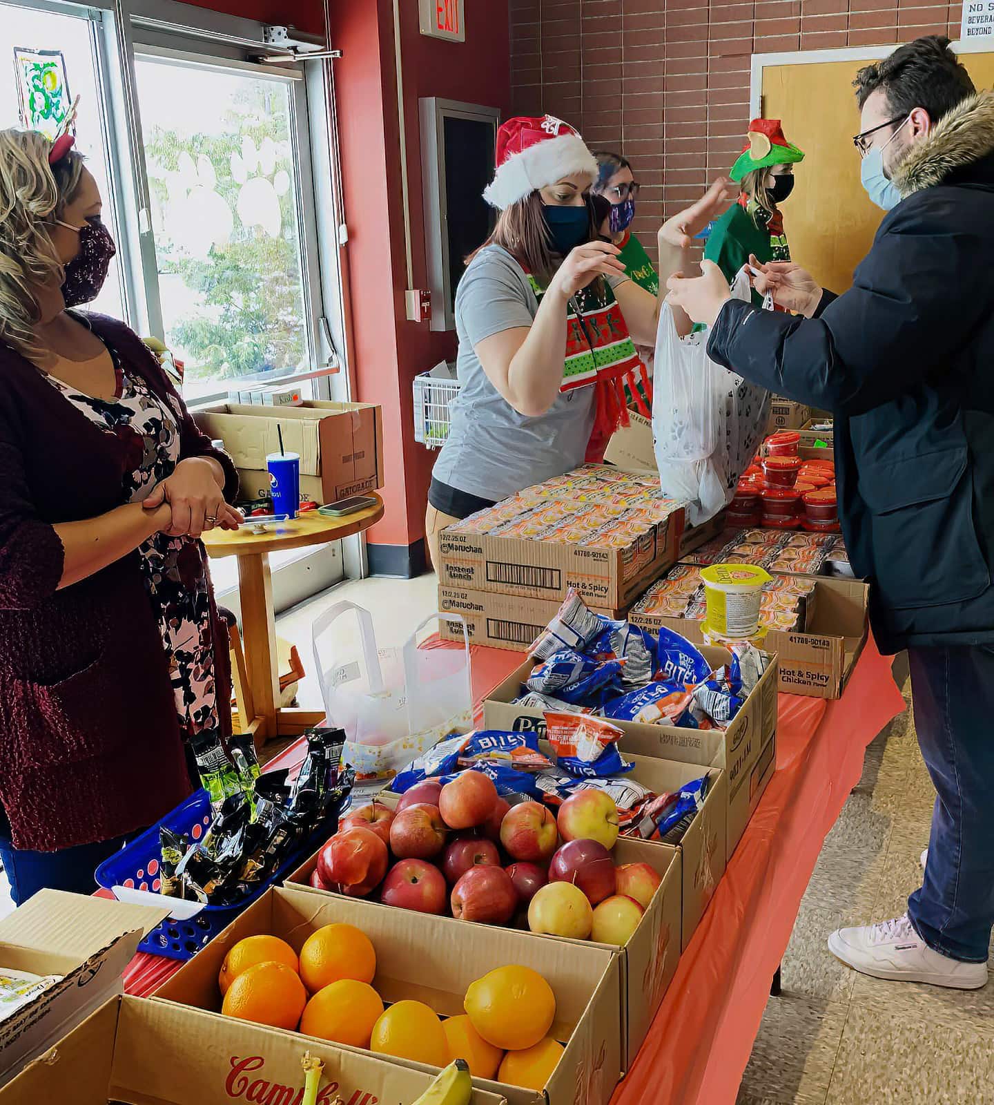 employees hand out food to students