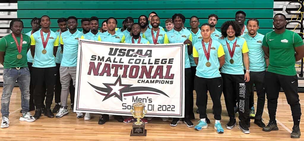 The 2022 UMFK Men’s Soccer team pose with their championship banner and trophy