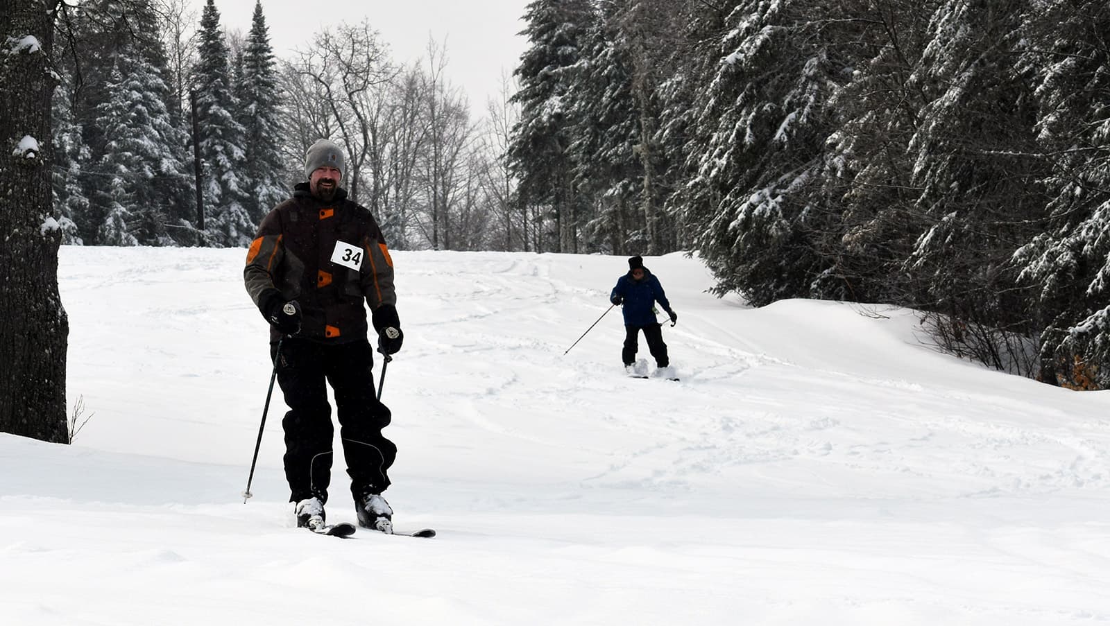 a duo downhill ski, the participant on the left-hand side of the photo in the lead