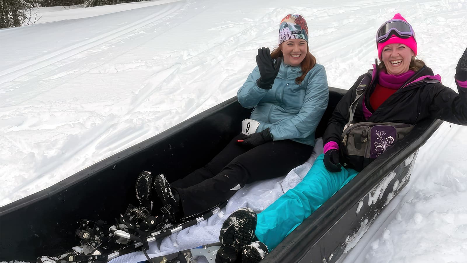 two female participants ride inside a sled