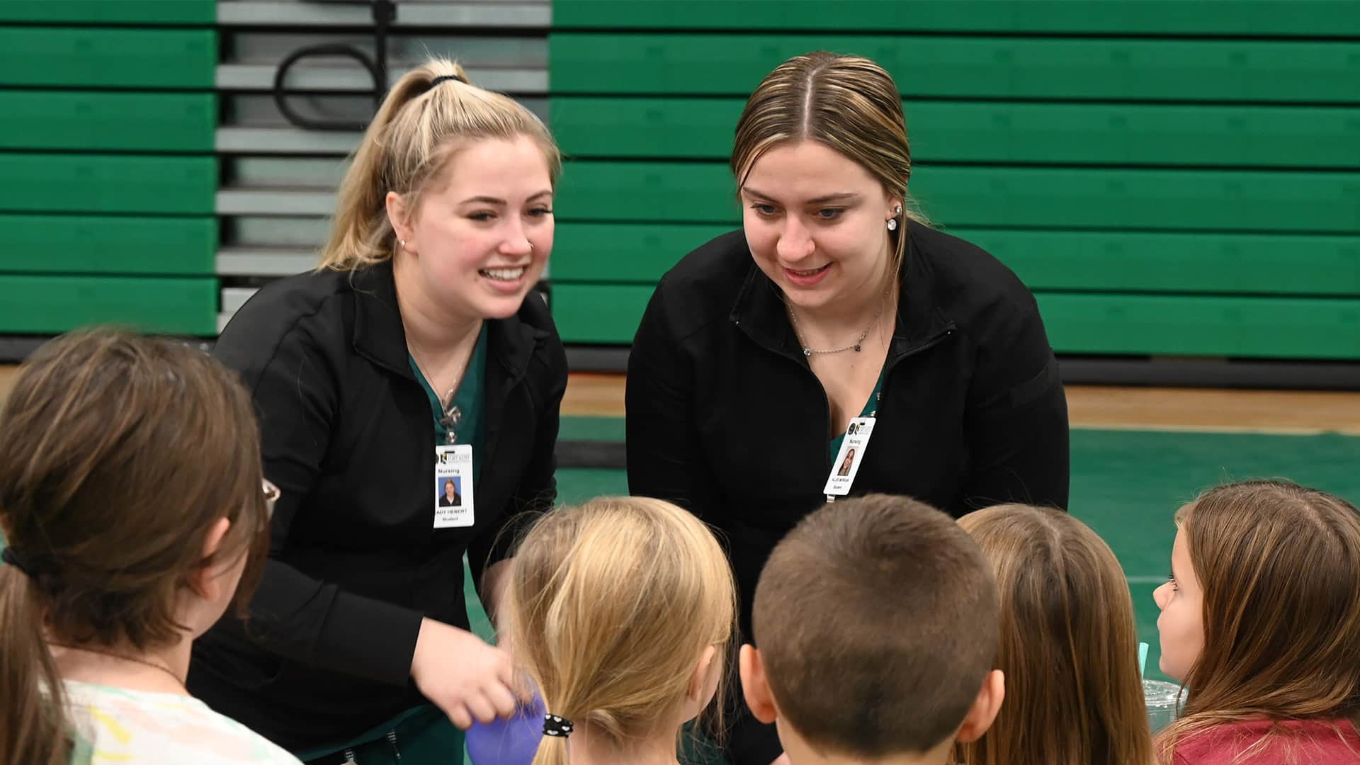 Two nursing students speak to a group of elementary school students during the 2023 pediatric health fair