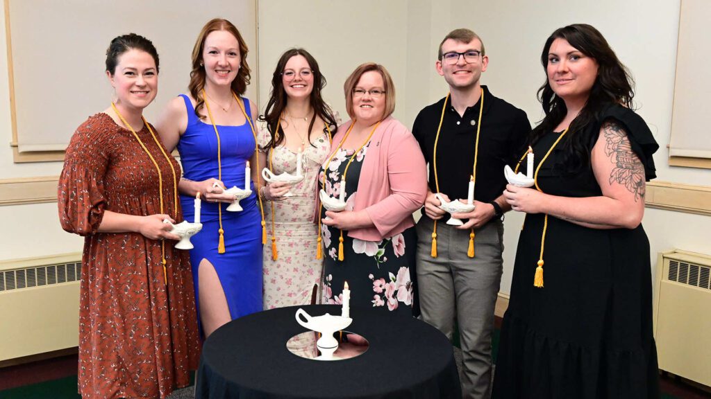 Sarah J. Brown; Brooke Caron; Kristyn Hatfield; Deanna Long; Hunter Milliard; and Tiffany E. Smith stand together around a table