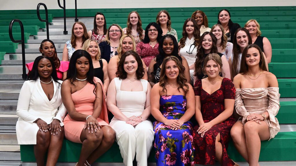 UMFK nursing students pose seated on bleachers in the UMFK Sports Center