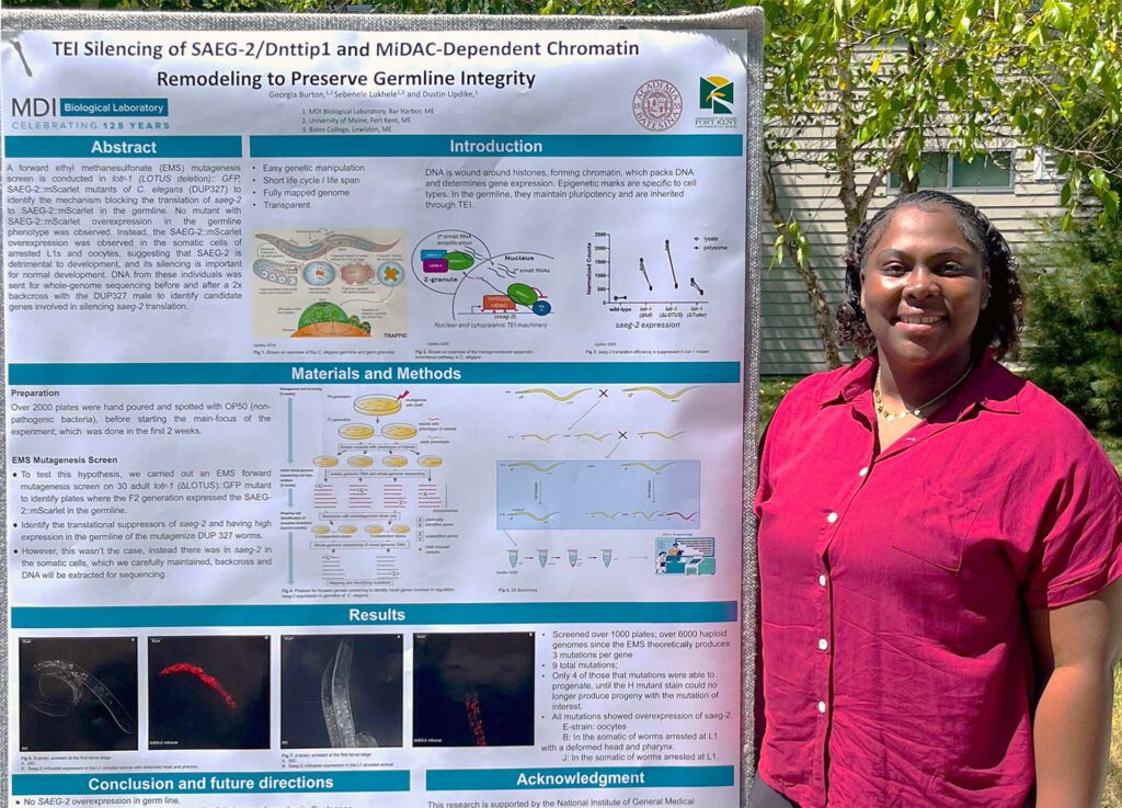 UMFK biology student Georgia Burton poses next to her research poster