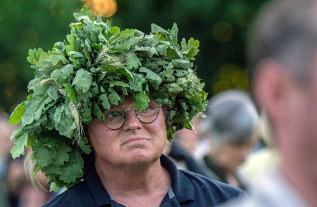 music professor Scott Brickman standing in a crowd, wearing a hat with leaves